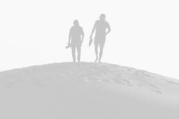 Two people standing on top of a hill.